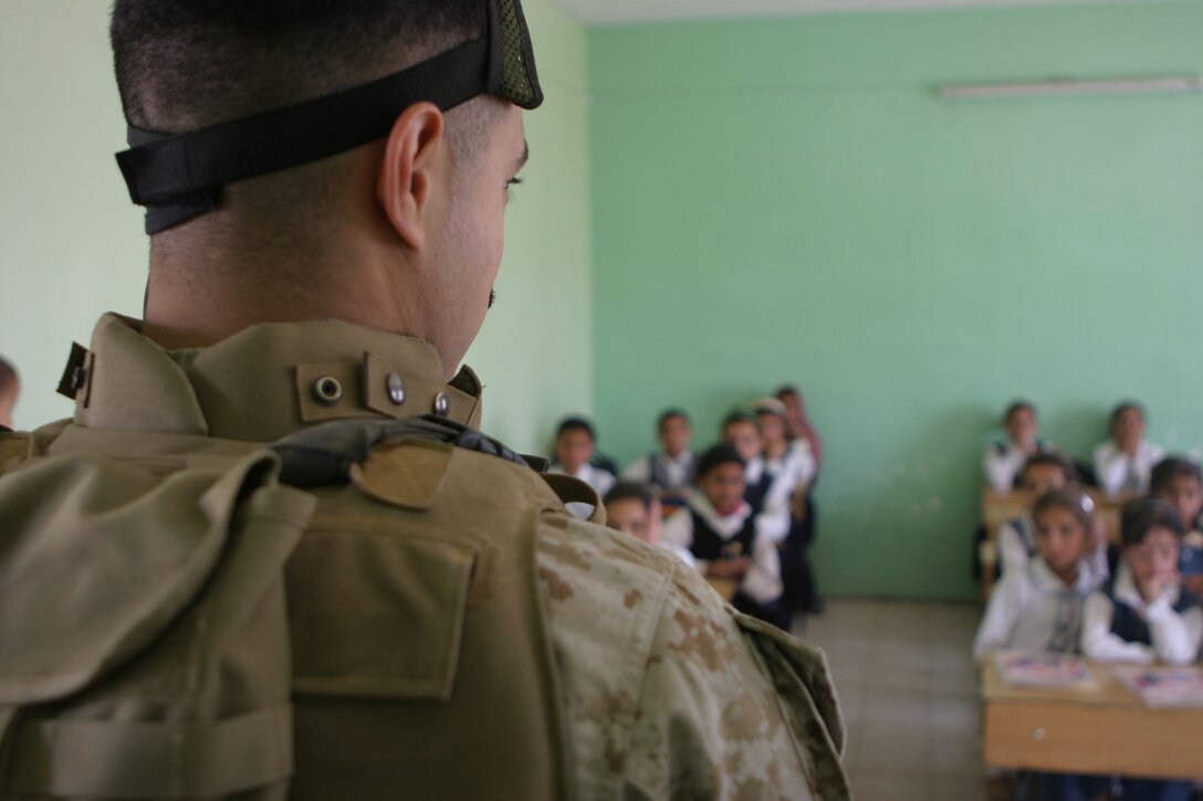 AL UBAYDI, Iraq (April 27, 2005)- 2nd Lt. Mario Mangiameli, the adjutant of 3rd Battalion, 2nd Marine Regiment, Regimental Combat Team-2, looks on at a class of Iraqi children during a school assessment here. The Marines of Task Force 3/2 discovered a lack of school supplies and some structural problems during their visit. Offical U.S. Marine Corps photo by Lance Cpl. Lucian Friel (RELEASED)