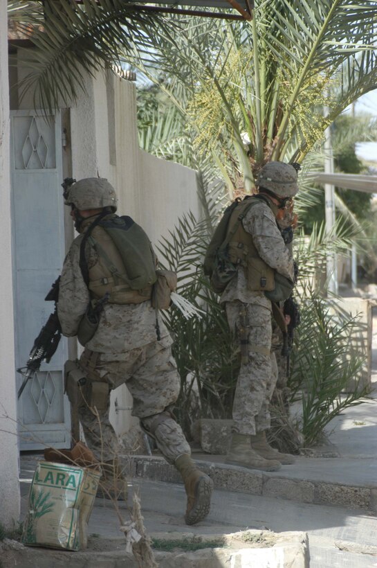 AR RAMADI, Iraq (May 16, 2005) - A Marine with 3rd Platoon, Company A, 1st Battalion, 5th Marine Regiment, runs through the entrance of a home here during a mission while his comrade posts security. Marines 3rd Platoon conducted a cordon and search mission of a neighborhood with 15 New Iraqi Army soldiers. The three-hour joint-operation was geared toward keeping a military presence in area and establishing a positive relationship between Iraqi civilians and members of their own military. The Marines and their Iraqi counterparts executed the mission without incident. Photo by Cpl. Tom Sloan