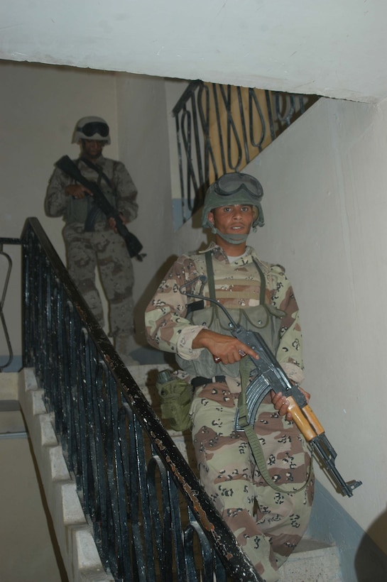 AR RAMADI, Iraq (May 16, 2005) -Two New Iraqi Army (NIA) soldiers walk down a staircase in a home here during a mission with Marines with 3rd Platoon, Company A, 1st Battalion, 5th Marine Regiment. Fifteen NIA soldiers accompanied Marines with 3rd Platoon and, together, conducted a cordon and search mission of a neighborhood. The three-hour joint-operation was geared toward keeping a military presence in area and establishing a positive relationship between Iraqi civilians and members of their own military. The Marines and their Iraqi counterparts executed the mission without incident. Photo by Cpl. Tom Sloan