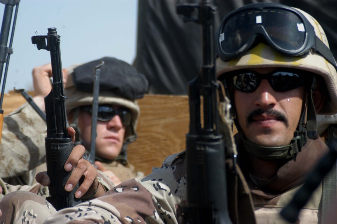 AR RAMADI, Iraq (May 16, 2005) - A New Iraqi Army (NIA) soldier sits in the back of a 7-ton truck Marines with 3rd Platoon, Company A, 1st Battalion, 5th Marine Regiment, as they travel to their destination in the city here for a mission. Fifteen NIA soldiers accompanied Marines with 3rd Platoon and, together, conducted a cordon and search mission of a neighborhood. The three-hour joint-operation was geared toward keeping a military presence in area and establishing a positive relationship between Iraqi civilians and members of their own military. The Marines and their Iraqi counterparts executed the mission without incident. Photo by Cpl. Tom Sloan