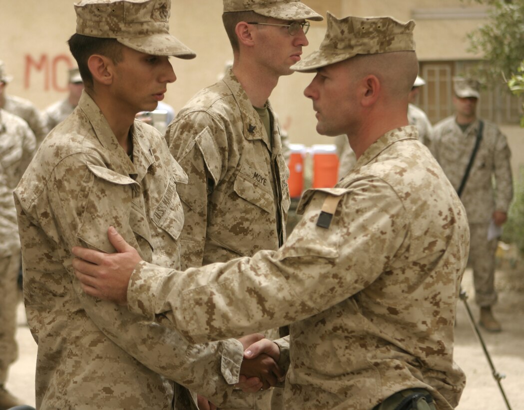 FALLUJAH, Iraq - First Sergeant John Elliott, Company B, 1st Battalion, 6th Marine Regiment's first sergeant, right, shakes hands with his Marines here June 16 after a memorial service honoring their fallen brother, Pfc. Joshua Klinger.  Klinger passed away June 14 when an improvised explosive device detonated near his position while patrolling Fallujah's streets.