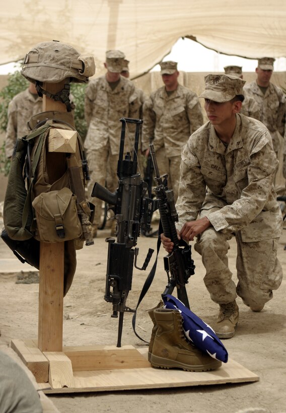 FALLUJAH, Iraq - A Marine with Company B, 1st Battalion, 6th Marine Regiment kneels down in front of Pfc. Joshua Klinger's gear display here June 16 to pay his final respects.  Klinger passed away June 14 when an improvised explosive device detonated near his position while patrolling Fallujah's streets.