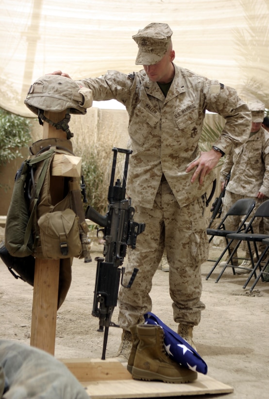 FALLUJAH, Iraq - 1st Lt. Thomas Waller, Company B, 1st Battalion, 6th Marine Regiment's company executive officer, pays his final respects to fellow Marine, Pfc. Joshua Klinger, after a memorial service here June 16.  Klinger passed away June 14 when an improvised explosive device detonated near his position while patrolling Fallujah's streets.