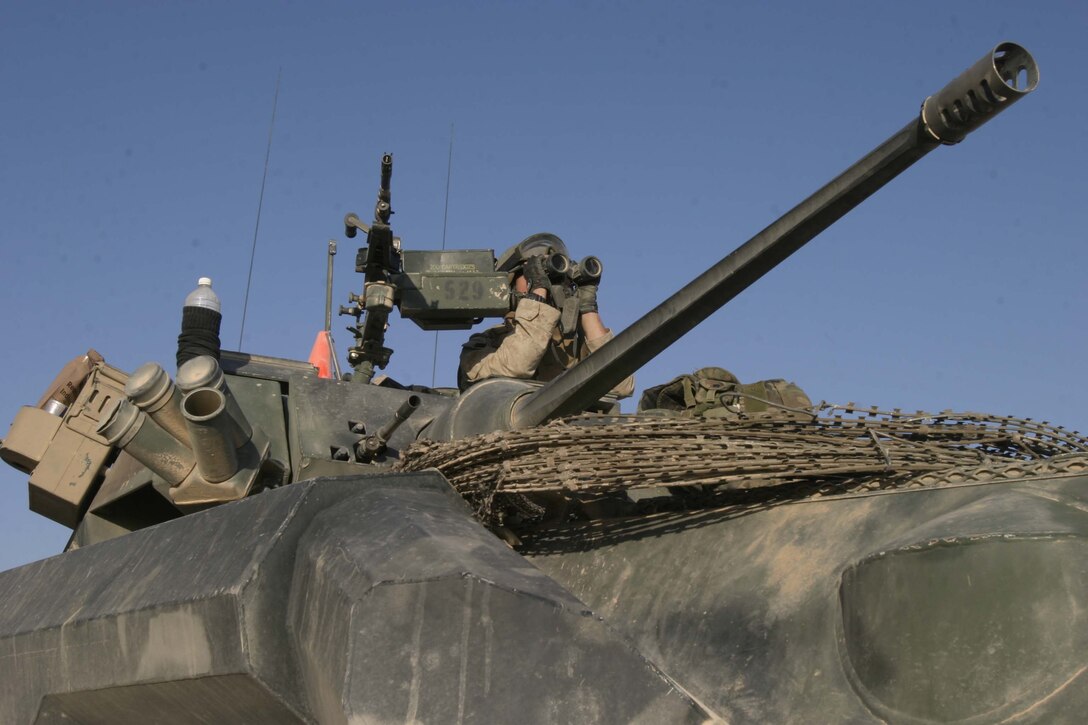 KARBALAH, Iraq- (June 18, 2005)  Cpl. Rodney A. Backues, from St. Louis, Mo., a Marine from 2D Light Armored Reconnaissance, Charlie Company, watches the city for insurgents while sitting in a Light Armored Vehicle. During Operation Spear, the Marines of 2d Marine Division conduct counter- insurgency operations with Iraqi Security Forces to isolate and neutralize anti-Iraqi forces, to support the continued development of Iraqi Security Forces, and to support Iraqi reconstruction and democratic elections in order to create a secure environment that enables Iraqi self-reliance and self-governance. (Official USMC photo by LCpl. Shane S. Keller) NOT RELEASED