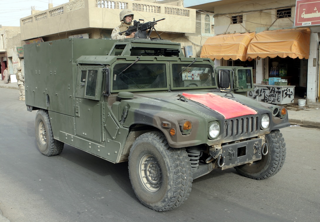 FALLUJAH, Iraq - Lance Cpl. Josh Griffin, an infantryman with Surveillance, Target and Acquisition Platoon, Company W, 1st Battalion, 6th Marine Regiment, provides security from atop his new MAK HMMWV (Marine Armor Kit equipped High Mobility Multi-Wheeled Vehicle) in a street in downtown Fallujah.  The 21-year-old Grenada, Miss. native's unit is currently receiving several of these hardened vehicles to protect the troops against roadside bomb detonation and small arms fire.