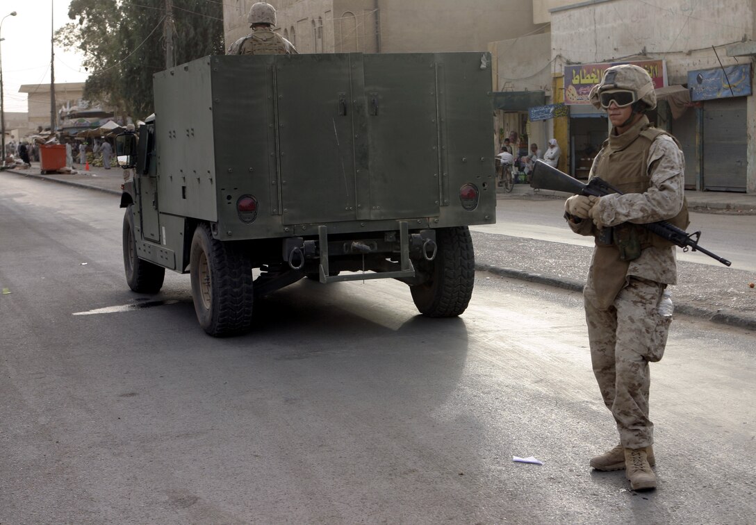 FALLUJAH, Iraq - Lance Cpl. Daniel Ramos, an infantryman with Surveillance, Target and Acquisition platoon, Company W, 1st Battalion, 6th Marine Regiment, provides security behind a new MAK HMMWV (Marine Armor Kit equipped High Mobility Multi-Wheeled Vehicle) in downtown Fallujah.  The 19-year-old Orange Park, Fla. native's unit is currently receiving several of these hardened vehicles to protect the troops against roadside bomb detonation and small arms fire.