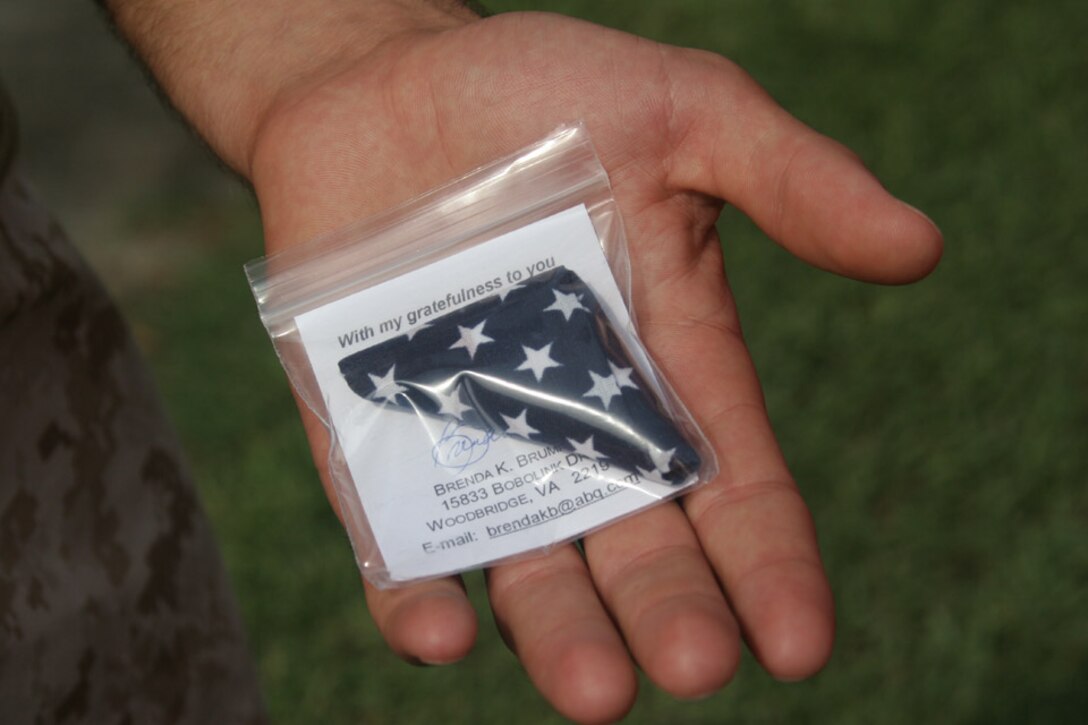 050715-M-2607O-012 MARINE CORPS BASE CAMP LEJEUNE, N.C. (July 15, 2005) -- A Marine from Headquarters and Service Company, 2nd Battalion, 2nd Marine Regiment, receives his pocket flag from Mrs. Brenda Brummer, a volunteer with the Pocket Flag Program.  Each Marine in the Company received a flag to put in their pocket or hang in their workspace.