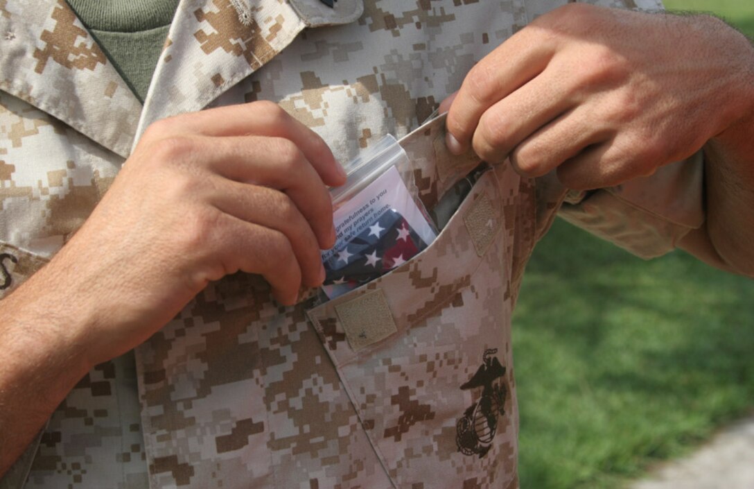 050715-M-2607O-013MARINE CORPS BASE CAMP LEJEUNE, N.C. (July 15, 2005) -- A Marine from Headquarters and Service Company, 2nd Battalion, 2nd Marine Regiment, places his pocket flag over his heart in his left breast pocket before leaving in support of the Global War on Terrorism.  Each Marine in the company was given a flag to put in their pocket or hang in their workspace.