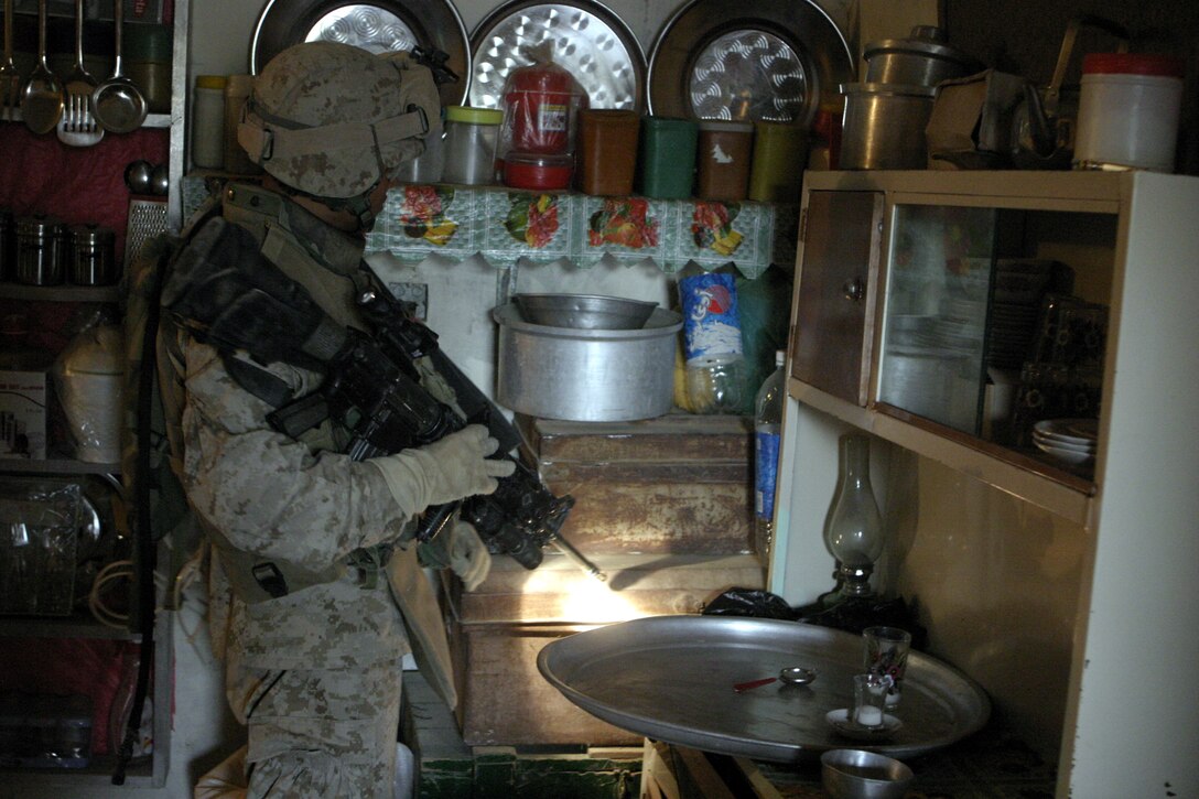 FALLUJAH, Iraq - Lance Cpl. Than Naing, a rifleman with 2nd Squad, 3rd Platoon, Company C, 1st Battalion, 6th Marine Regiment, searches inside a household here July 16 during Operation Hard Knock.  Company C personnel worked alongside other battalion infantrymen and Iraqi Security Forces to search through a wired-off sector of Fallujah for weapons and insurgent activity, as well as gather census information on the populace.