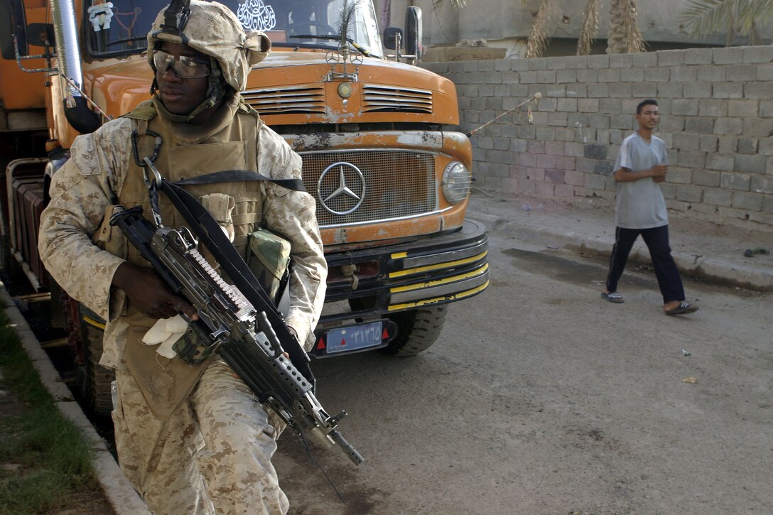 FALLUJAH, Iraq - Lance Cpl. Scott Pierre, a squad automatic gunner with 2nd Squad, 3rd Platoon, Company C, 1st Battalion, 6th Marine Regiment, provides security along a street here July 16 during Operation Hard Knock.  The 21-year-old Fort Lauderdale, Fla. native worked alongside other battalion infantrymen and Iraqi Security Forces to search through a wired-off sector of Fallujah for weapons and insurgent activity, as well as gather census information on the populace.