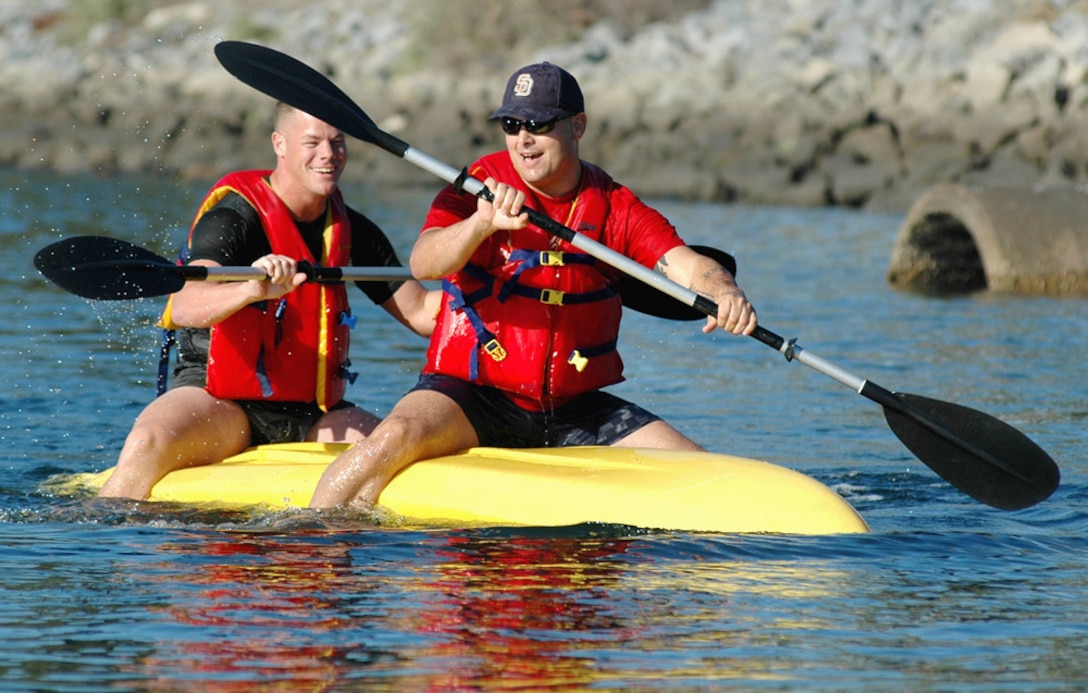 Staff Sgts. Greg Isaacson and Sid Gonzalez, Receiving Company drill instructors, RTR, paddle a capsized kayak to finish a relay race. Their vessel flipped after converging with opponents from the Coast Guard and Headquarters and Service Battalion. Coast Guard won the heat and placed first and third in the event.