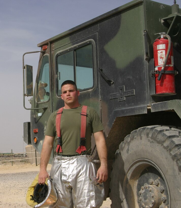 AL QAIM, Iraq - Lance Cpl. Daniel Nance an Aircraft, Rescue and Fire Fighting Marine with Marine Wing Support Squadron 271 stands in front of a P-19 here. Nance joined the Marine Corps in 2003 and became a firefighter like his stepfather who has more than 30 years of firefighting experience.