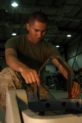 AL ASAD, Iraq - Corporal Walter Vidal, an airframe mechanic with Marine Aviation Logistics Squadron 26 fixes a gun turret at the MALS-26 compound, May 17.  MALS-26?s maintenance division doesn?t measure its effectiveness in turn-around time or repair time, but squadron readiness. They prioritize their parts in order of demand and repair the most critical parts first.