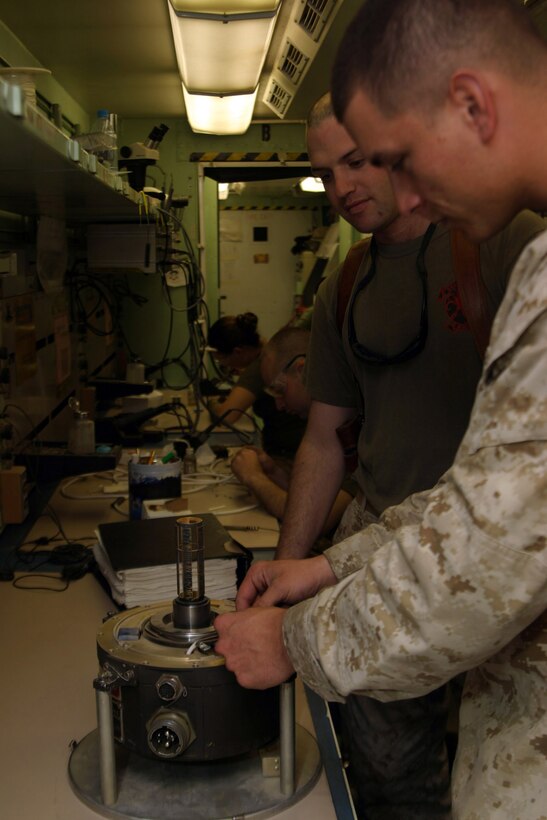 AL ASAD, Iraq - Staff Sgt. John Degrasse an avionics non commissioned officer in charge with Marine Aviation Logistics Squadron 26 explains a cable wiring problem to Cpl. Robert Ortega an avionics technician with MALS-26, May 17. The ?Patriots? have successfully kept a 85/80 readiness rate for a week now and continue to strive to find better ways to do their job more effiently while increasing the readiness of their flying squadrons.