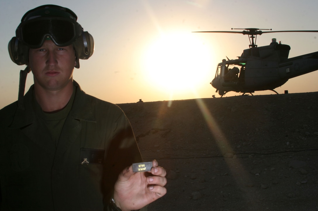 Lance Cpl. Cole Wilcox, an airframes mechanic with the Gunfighters and LeRoy, Minn., native, holds the GT66 WWNF, Gunshot 66 we will never forget, patch, Nov. 17, at Al Qaim, Iraq. Gunshot 66 was the call sign Capt. Mike Martino and Maj. Jerry Bloomfield, both AH-1 Cobra pilots with the Gunfighters, had when their Cobra crashed to the ground, Nov. 2, in support of operations out of Al Taqqadum, Iraq.