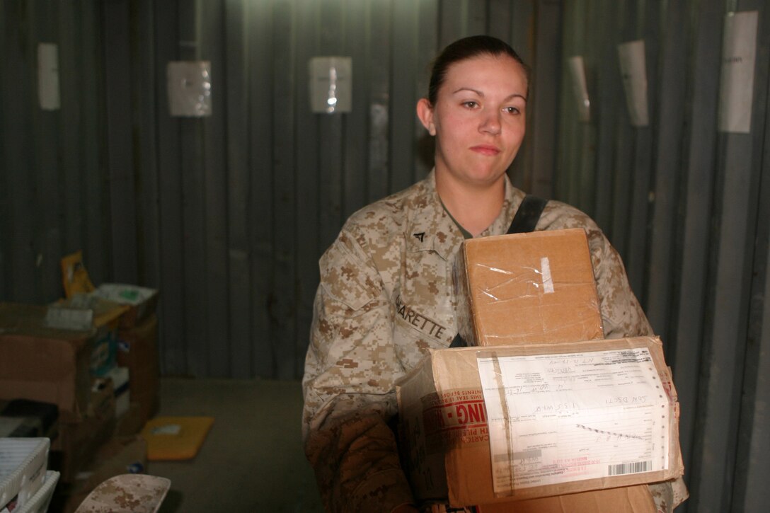 Lance Cpl. Holly Charette, a 21-year-old from Cranston, R.I., delivers Headquarters Battalion Marines' mail, March 17.  Charette recently deployed here from her home base at Camp Lejeune, N.C. to serve in Operation Iraqi Freedom.  U.S. Marine Corps photo by Sgt. Stephen D'Alessio (RELEASED)