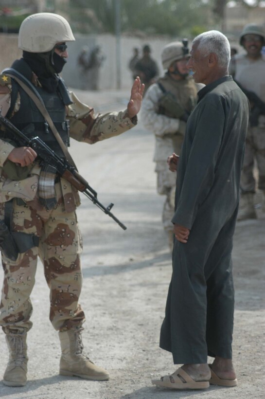 AR RAMADI, Iraq (April 17, 2005) - A lieutenant with the Iraqi Intervention Forces talks to an elderly Iraqi man during a patrol through the city here. Iraqi people are more receptive to having fellow Iraqis patrol through their neighborhoods. Fifteen IIF members accompanied Marines with 3rd Platoon, Company C, 1st Battalion, 5th Marines, and, together, conducted a combat patrol. The three-hour joint-mission was geared towards fine-tuning the IIF members' patrolling techniques by providing them with hands-on training in a combat environment. Marines with 3rd Platoon, Company C, 1st Battalion, 5th Marines, showed their IIF counterparts proper dispersion, how to post security and set up over watches and other patrolling fundamentals. In the not so distant future, the IIF assume full responsibility of conducting security and stabilization operations when they are competent enough to successfully patrol the city on their own.  Photo by Cpl. Tom Sloan