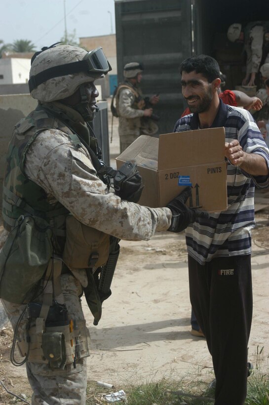 AR RAMADI, Iraq (May 17, 2005) - A smiling, Iraqi man hands a box of medical supplies to Gunnery Sgt. Wayne B. McClam, the team chief for Team 1, Detachment 3, 5th Civil Affairs Group, which is in direct support of 1st Battalion, 5th Marine Regiment, during a mission at the Maternity and Children's Hospital here. The 37-year-old from Lake City, S.C., joined other Marines with the infantry battalion and soldiers from the Army's 2nd Brigade Combat Team and conducted an operation to improve medical care for residents of the city and foster good will toward coalition forces. The Marines and soldiers delivered four sea containers of medical supplies - valued at more than $500,000 - to the hospital. The supplies ranged from heart monitors and antibiotics to new bed sheets and bandages. Photo by: Cpl. Tom Sloan