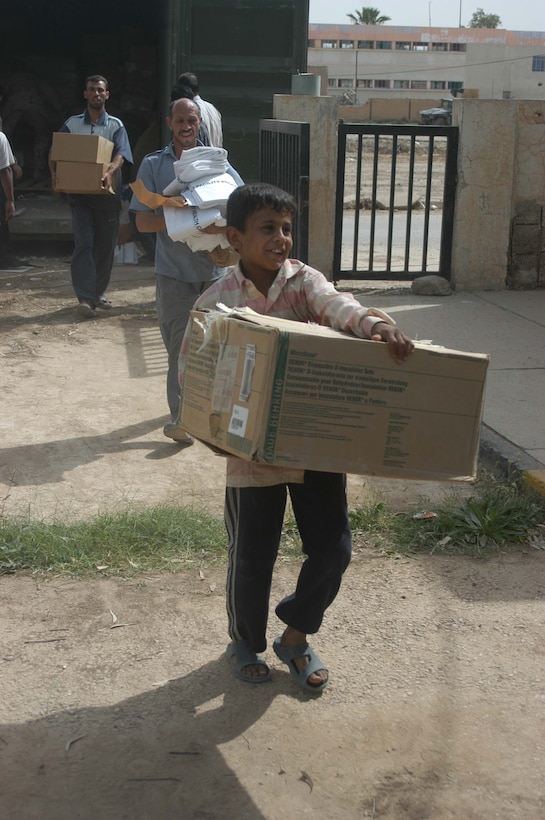 AR RAMADI, Iraq (May 17, 2005) - A young, Iraqi boy smiles as he carries a box of medical supplies from a sea container into the Maternity and Children's Hospital here. Marines with 1st Battalion, 5th Marine Regiment, and soldiers from the Army's 2nd Brigade Combat Team and conducted an operation to improve medical care for residents of the city and foster good will toward coalition forces. The Marines and soldiers delivered four sea containers of medical supplies - valued at more than $500,000 - to the hospital. The supplies ranged from heart monitors and antibiotics to new bed sheets and bandages. Photo by: Cpl. Tom Sloan