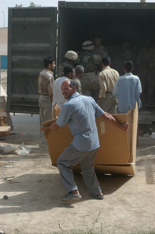 AR RAMADI, Iraq (May 17, 2005) - An Iraqi man smiles as he drags a box of medical supplies from a sea container into the Maternity and Children's Hospital here. Marines with 1st Battalion, 5th Marine Regiment, and soldiers from the Army's 2nd Brigade Combat Team and conducted an operation to improve medical care for residents of the city and foster good will toward coalition forces. The Marines and soldiers delivered four sea containers of medical supplies - valued at more than $500,000 - to the hospital. The supplies ranged from heart monitors and antibiotics to new bed sheets and bandages. Photo by: Cpl. Tom Sloan