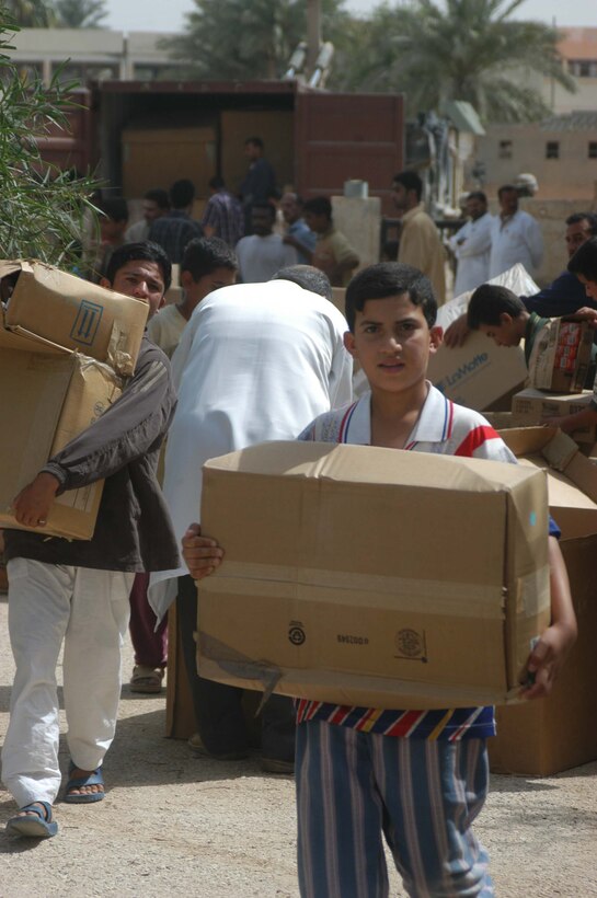 AR RAMADI, Iraq (May 17, 2005) - Carrying a box of medical supplies, an Iraqi boy negotiates his way around several other boxes of supplies staged in the parking lot of the Maternity and Children's Hospital here. Marines with 1st Battalion, 5th Marine Regiment, and soldiers from the Army's 2nd Brigade Combat Team and conducted an operation to improve medical care for residents of the city and foster good will toward coalition forces. The Marines and soldiers delivered four sea containers of medical supplies - valued at more than $500,000 - to the hospital. The supplies ranged from heart monitors and antibiotics to new bed sheets and bandages. Photo by: Cpl. Tom Sloan