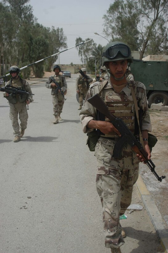 AR RAMADI, Iraq (May 17, 2005) - A member of the Iraqi Security Forces conducts a patrol with his Iraqi comrades and Marines with 1st Battalion, 5th Marine Regiment's Company C during a mission at the Maternity and Children's Hospital here. A squad of ISF members helped provide security while Marines with 1st Battalion, 5th Marine Regiment, and soldiers from the Army's 2nd Brigade Combat Team conducted an operation to improve medical care for residents of the city and foster good will toward coalition forces. The Marines and soldiers delivered four sea containers of medical supplies - valued at more than $500,000 - to the hospital. The supplies ranged from heart monitors and antibiotics to new bed sheets and bandages. Photo by: Cpl. Tom Sloan