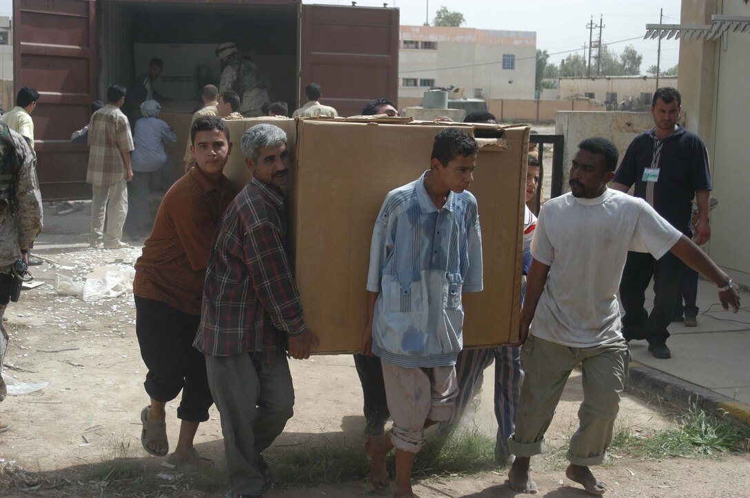 AR RAMADI, Iraq (May 17, 2005) - A group of Iraqi men carry a box of medical supplies from a sea container into the Maternity and Children's Hospital here. Marines with 1st Battalion, 5th Marine Regiment, and soldiers from the Army's 2nd Brigade Combat Team and conducted an operation to improve medical care for residents of the city and foster good will toward coalition forces. The Marines and soldiers delivered four sea containers of medical supplies - valued at more than $500,000 - to the hospital. The supplies ranged from heart monitors and antibiotics to new bed sheets and bandages. Photo by: Cpl. Tom Sloan