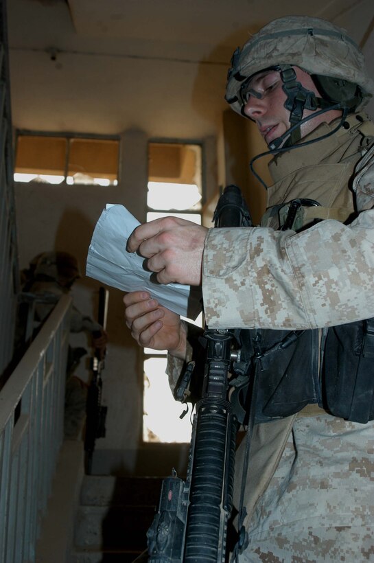 AR RAMADI Iraq (June 17, 2005) - Corporal Matt I. Bremer, a squad leader for 2nd Squad, 2nd Platoon, Company A, 1st Battalion, 5th Marines, checks his squad's position on his map during a mission in the city here. The 22-year-old from Winston Salem, N.C., and his fellow 2nd and 3rd Platoon, Company A warriors' were conducting a search mission when they were called on to provide security for a platoon of Company C Marines who hit an IED. The Marines set up lookouts on rooftops a few hundred yards from the attack seen. They remained in their surveillance positions for more than two hours. Photo by: Cpl. Tom Sloan