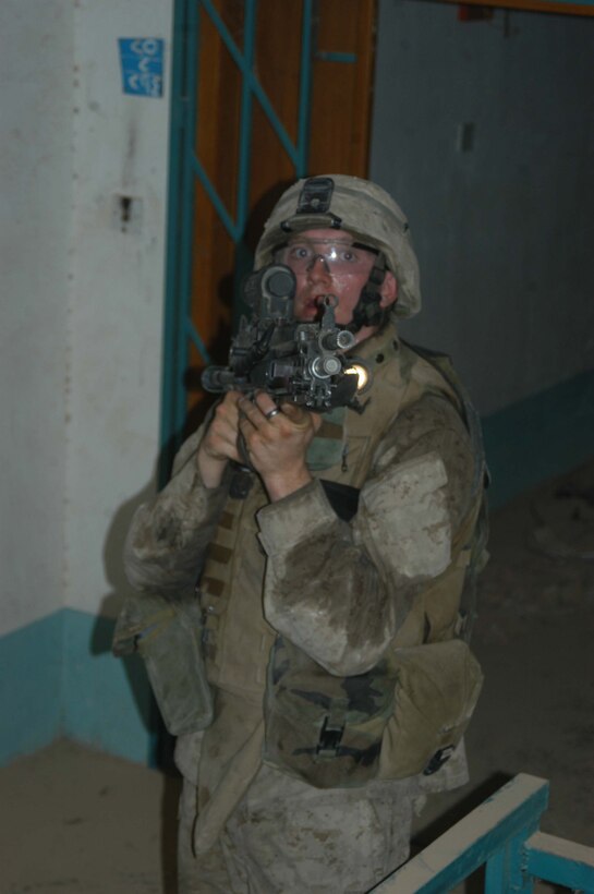 AR RAMADI Iraq (June 17, 2005) - Lance Cpl. Michael S. Fisher, a squad automatic weapon gunner, with 2nd Squad, 2nd Platoon, Company A, 1st Battalion, 5th Marine Regiment, has his weapon at the ready and posts security for his comrades from within a building during a mission in the city here. The 21-year-old from Minneapolis, and his fellow 2nd and 3rd Platoon, Company A warriors' were conducting a search mission when they were called on to provide security for a platoon of Company C Marines who hit an IED. The Marines set up lookouts on rooftops a few hundred yards from the attack seen. They remained in their surveillance positions for more than two hours. Photo by: Cpl. Tom Sloan