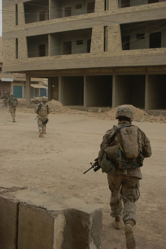 AR RAMADI Iraq (June 17, 2005) - Marines with 2nd Squad, 2nd Platoon, Company A, 1st Battalion, 5th Marine Regiment, cutout across an open courtyard during a search mission in the city here. Marines with Company A's 2nd and 3rd Platoons were conducting a search mission when they were called on to provide security for a platoon of Company C Marines who hit an IED. The Marines set up lookouts on rooftops a few hundred yards from the attack seen. They remained in their surveillance positions for more than two hours. Photo by: Cpl. Tom Sloan