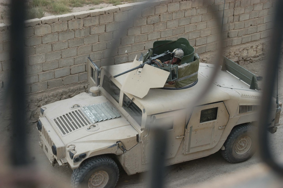 AR RAMADI Iraq (June 17, 2005) - A Marine with 2nd Platoon, Company A, 1st Battalion, 5th Marine Regiment, sits in the turret of a Humvee and provides security with his M2.50 Caliber Machine Gun during a search mission in the city here. Marines with Company A's 2nd and 3rd Platoons were conducting a search mission when they were called on to provide security for a platoon of Company C Marines who hit an IED. The Marines set up lookouts on rooftops a few hundred yards from the attack seen. They remained in their surveillance positions for more than two hours. Photo by: Cpl. Tom Sloan