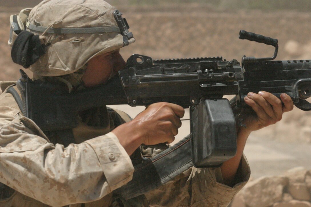 KARABILAH, Iraq- (June 17, 2005)- Pfc. Nathan W. Pesch-Scott, a squad automatic weapon gunner with 3rd Squad, 3rd Platoon, Company K, 3rd Battalion, 2nd Marine Regiment opens fire on a sniper in Karabilah after recieving fire.  Operation Spear is conducted to destroy insurgency leadership strong points.  The Marines of 2d Marine Division conduct counter-insurgency operations with Iraqi Security Forces to isolate and neutralize anti-Iraqi forces, to support the continued development of Iraqi Security Forces, and to support Iraqi reconstruction and democratic elections in order to create a secure environment that enables Iraqi self-reliance and self-governance. (Official USMC photo by Cpl. Neill A. Sevelius (RELEASED)
