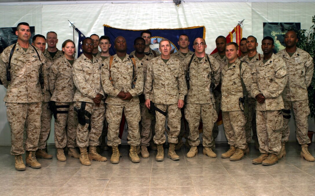 Member of the Navy's Hospital Corps deployed with Headquarters Company, Headquarters Battalion, 2nd Marine Division pose with Maj. Gen. Richard A. Huck after a cake cutting ceremony held here June 17 to honor the 107th birthday of the most decorated job field in naval history.