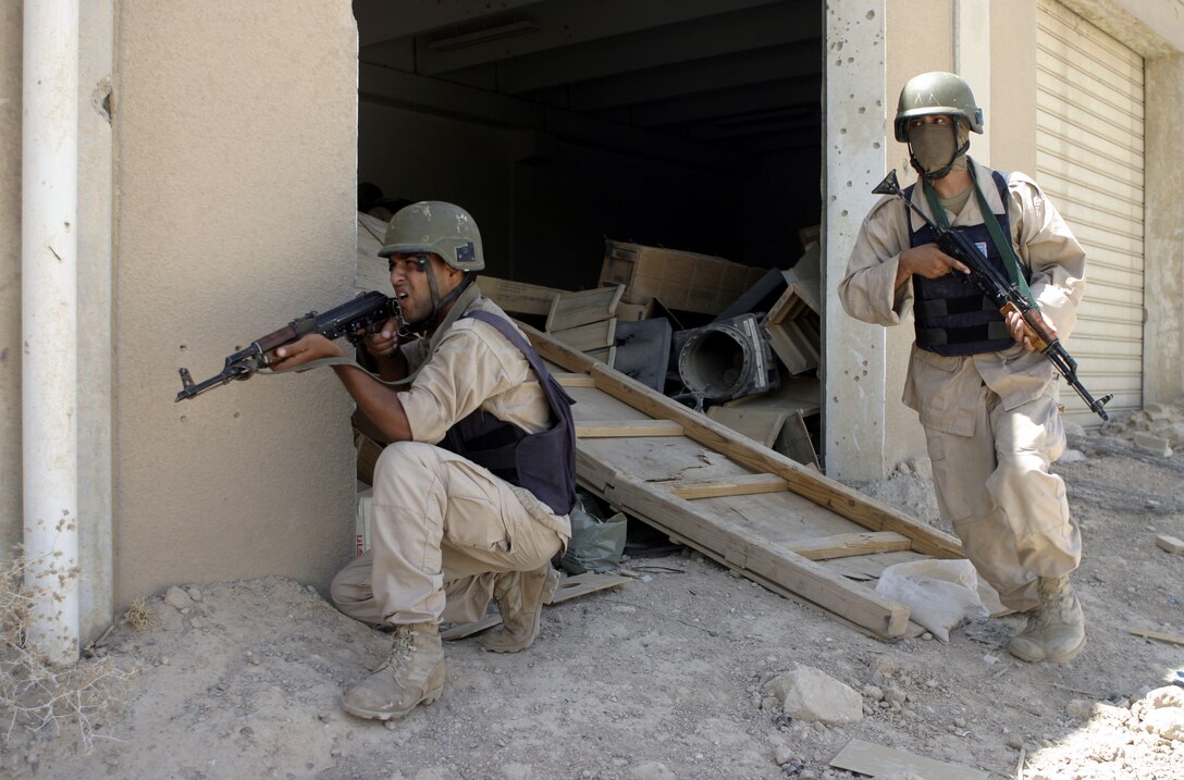 FALLUJAH, Iraq - Iraqi policemen rush forward as a team toward a hostile structure during a final training evolution 1st Battalion, 6th Marine Regiment's Iraqi Security Forces training cadre personnel supervised here Aug. 4.  Since mid-March, 1st Battalion, 6th Marine Regiment personnel have trained approximately 600 Iraqi troops on topics such as first aid in combat, infantry tactics, and convoy driving skills.  Iraqi forces are fully integrated into every operation the battalion's Marines and sailors conduct in and around the city.