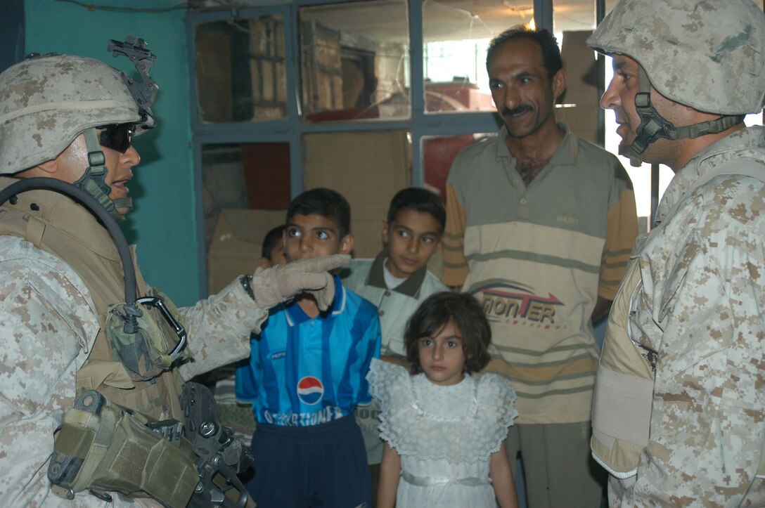 AR RAMADI, Iraq (April 9, 2005) - Staff Sgt. Ramon E. Gonzales, platoon sergeant, 2nd Platoon, Company C, 1st Battalion, 5th Marines, talks to an Iraqi man by using an interpreter during a mission here. Thirty-one-year-old GonzalesCordova from San Pedro, Honduras fell on Ramadi's urban battlefield Aug. 8 while fighting terror. A memorial ceremony was held in his honor at Camp Ramadi Aug. 17. He leaves behind his wife, Joselyn, and son, Sergio. Photo by: Cpl. Tom Sloan
