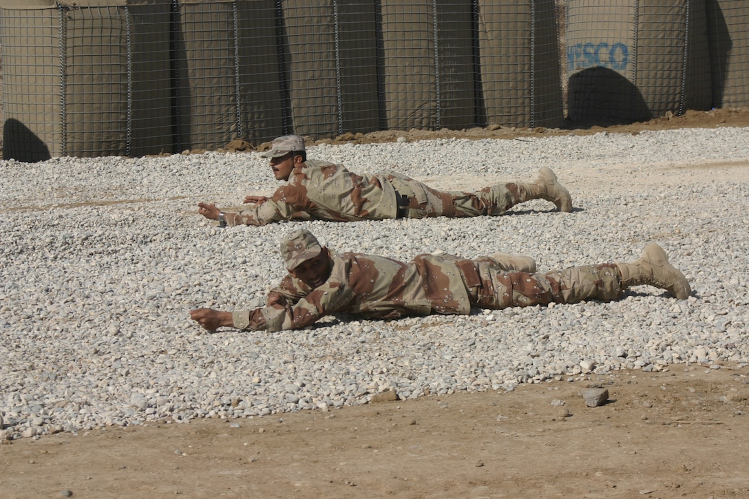 Two Iraqi Army soldiers with the 3rd Brigade, 7th Division lay in the prone position while conducting fire-team maneuvers at the An Numaniyah Training Base in An Numaniyah, Iraq near the Iranian border. The IA soldiers are being trained by a U.S. led Military Transition Team whose job is to man, train, equip and deploy with their Iraqi counterparts to the Western Al Anbar province in order to set conditions for the future transfer of the province to IA control.