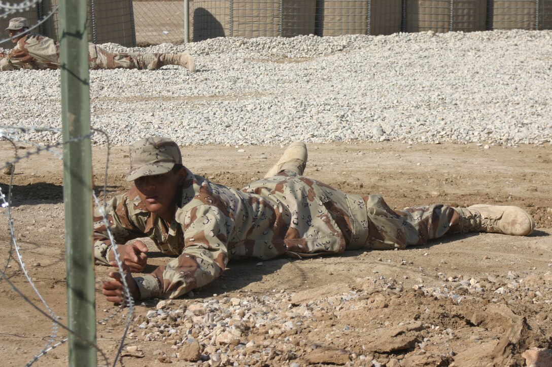 An Iraqi Army soldier with 3rd Brigade, 7th Division lies in the prone position while conducting fire-team maneuvers at the An Numaniyah Training Base in An Numaniyah, Iraq near the Iranian border. The IA soldier are being trained by a U.S. led Military Transition Team whose job is to man, train, equip and deploy with their Iraqi counterparts to the Western Al Anbar province in order to set conditions for the future transfer of the province to IA control.