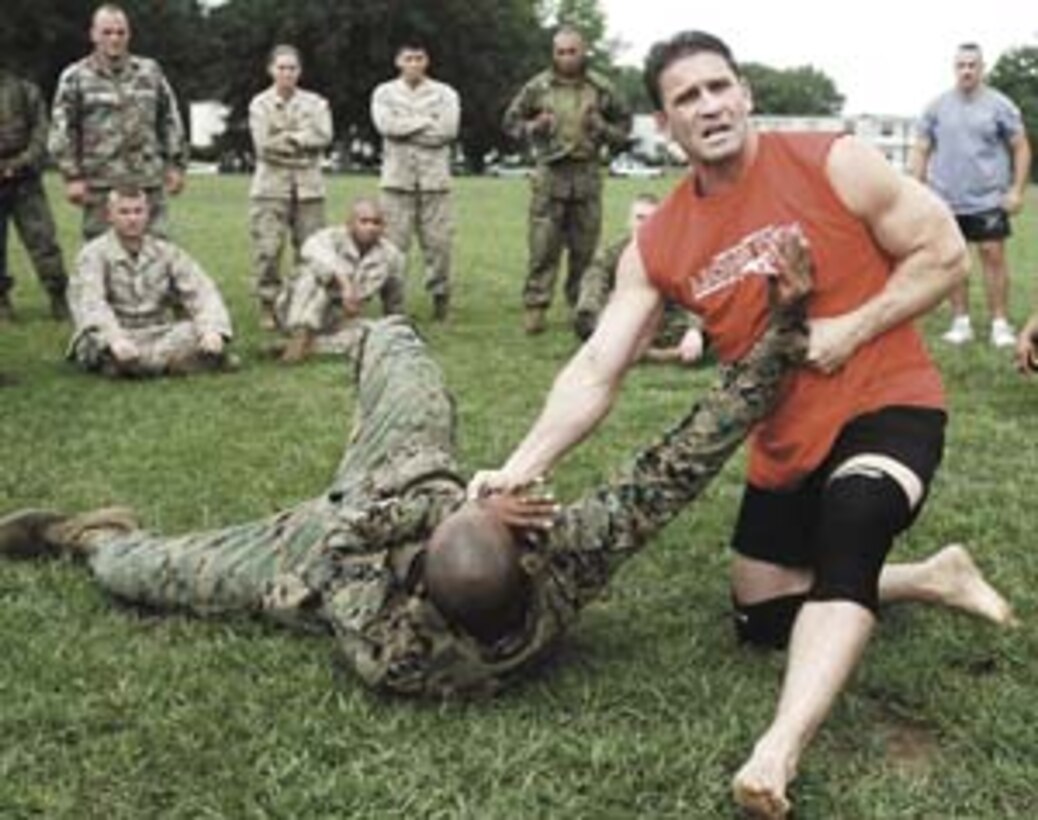Ken Shamrock, four-time mixed martial arts world champion and Marine Corps Martial Arts Program subject matter expert, demonstrates a finishing move August 17 for students and instructors at the Martial Arts Center of Excellence here. Shamrock emphasized the need to kill an enemy combatant within three to five seconds. ?When (Marines) are getting engaged in hand-to-hand combat, they don?t have time to roll around in the dirt,? said Shamrock. ?They need to finish the person quickly and get out.?