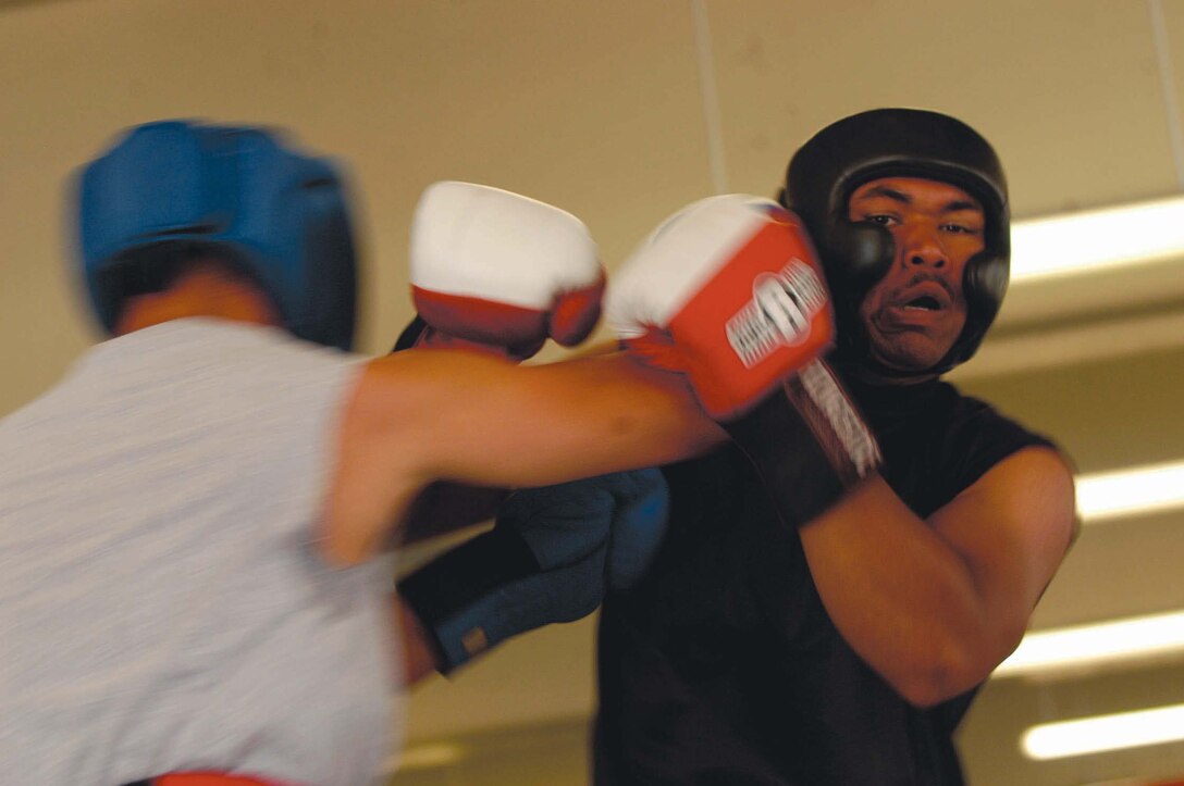 Felix Perez from 1st Medical Bn., slugs 9th Comm.?s Dalawn Dezhi during tryouts Sunday at the 33 Area Gym.