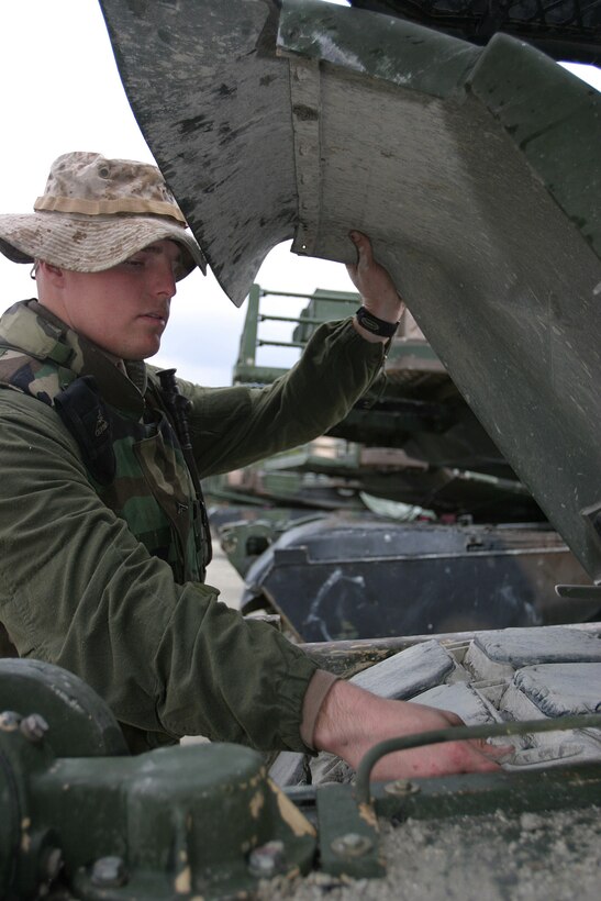 MARINE CORPS BASE CAMP LEJEUNE, N.C. (Feb. 14, 2004) - Lance Cpl. John. O. Young, a Nampa, Idaho native, and tank driver checks the tightness of the track on his M1-A1 Abrams Tank during a field operation here recently. Young and 27 other Marines from his former battalion in Boise are performing training exercises and adapting to their newfound active duty lifestyle before deploying in support of Operation Iraqi Freedom.