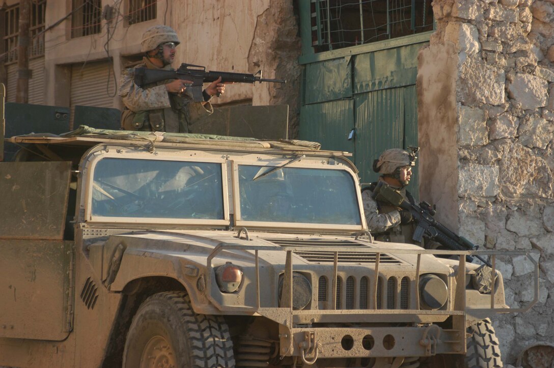 AR RAMADI, Iraq (March 18, 2005) - Two Marines with Company A, 1st Battalion, 5th Marine Regiment provide security during a patrol though the busy marketplace here. Marines with Company A, 1st Battalion, 5th Marine Regiment patrolled through the busy marketplace here in an effort to become more familiar with their area of operations and make their presents know to the local populace. The Marines also searched several building and a nearby mosque for weapons caches and insurgents. The three-hour patrol ended with the Marine returning empty handed to their base camp at Hurricane Point. Photo by Cpl. Tom Sloan