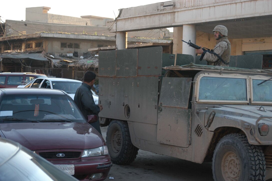 AR RAMADI, Iraq (March 18, 2005) - A Marine with Company A, 1st Battalion, 5th Marine Regiment, provides security while riding in an up-armored humvee through the congested streets here. Marines with Company A, 1st Battalion, 5th Marine Regiment patrolled through the busy marketplace here in an effort to become more familiar with their area of operations and make their presents know to the local populace. The Marines also searched several building and a nearby mosque for weapons caches and insurgents. The three-hour patrol ended with the Marine returning empty handed to their base camp at Hurricane Point. Photo by Cpl. Tom Sloan