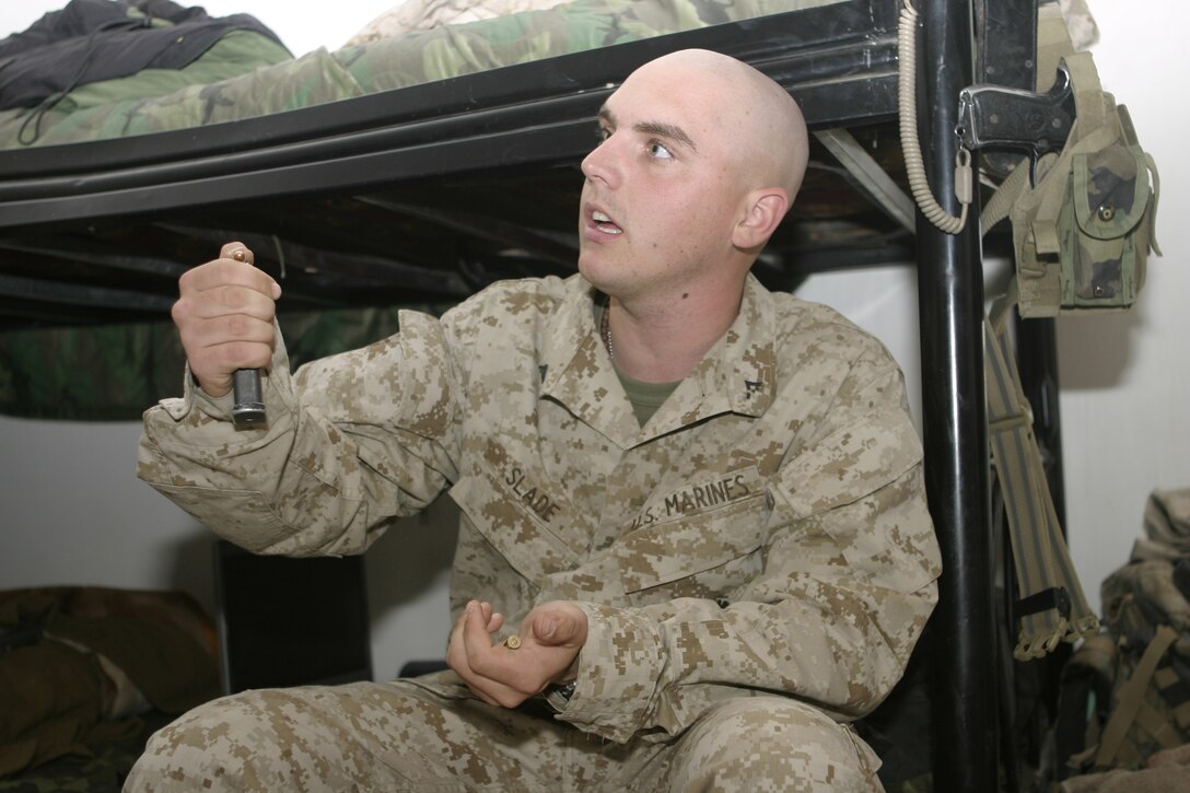 FALLUJAH, Iraq - Lance Cpl. Matthew L. Slade, Company A, 1st Battalion, 6th Marine Regiment armory custodian, attempts to fix a pistol magazine.  The 22-year-old Chandler, Ariz. native is currently deployed to Iraq, where he maintains accountability of his unit's rifles, machineguns and various other weapons.