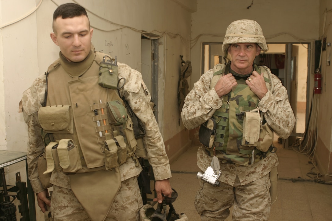 SAQLAWIYAH, Iraq - 1st Lt. Michael Regner, Company A, 1st Battalion, 6th Marine Regiment executive officer, left, gives Oliver North a tour through Company A's base of operations here May 9.  North is currently visiting U.S. servicemembers throughout Iraq and reporting on the joint Iraqi-Coalition civil-military accomplishments.