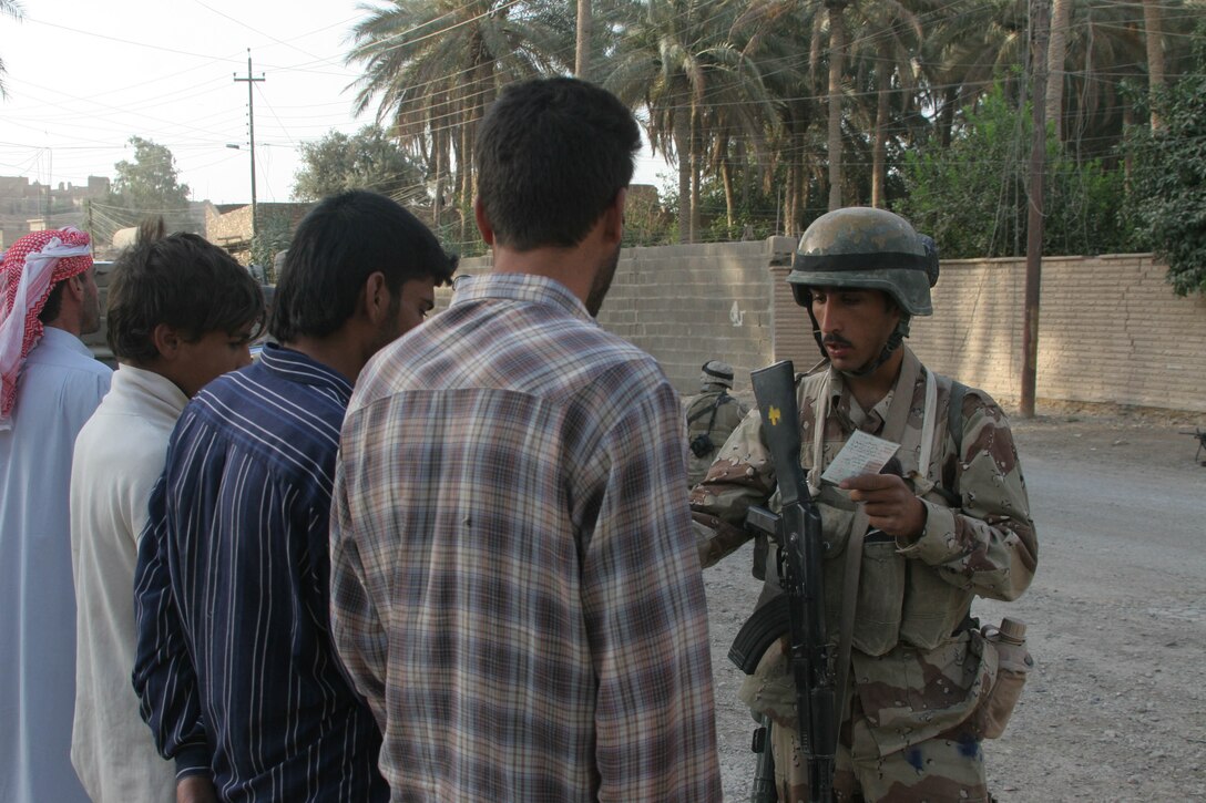 HIT, Iraq (July 4, 2005)- Iraqi soldiers with 1st Platoon, Company K, 3rd Battalion, 25th Marine Regiment, Regimental Combat Team-2 search local citizens while they conduct patrols to keep the streets safe during Operation Guardian Sword conducted to clear the city and set-up Iraqi Security Forces firm bases through out the city. (Official USMC photo by Lance Cpl. Lucian Friel )(NOT RELEASED)