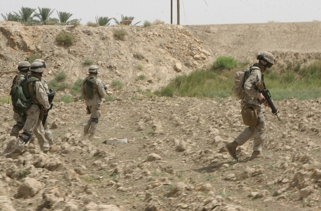 CAMP BLUE DIAMOND, AR RAMADI, Iraq - Members of the band patrol the town, July 15, looking for insurgent weapons or encampments.  The Camp Lejeune, N.C.-based band, normally accustomed to the business of playing ceremonial military music for changes of command and the Marine Corps birthday ball, changed their focus more than a year ago when they found out they would become headquarters battalion's main defense against insurgent attacks.  U.S. Marine Corps photo by Sgt. Stephen D'Alessio (RELEASED)