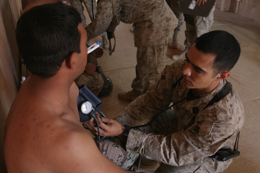 CAMP AL QA'IM, Iraq (July 18, 2005)- Hospital Corpsman 3rd Class (FMF) Roman Cadena, Jr., a corpsman with 3rd Battalion, 2nd Marine Regiment, Regimental Combat Team-2 from Weslaco, Texas, checks an Iraqi soldiers blood pressure during a medical screening here. (Official U.S. Marine Corps photo by Lance Cpl. Lucian Friel (RELEASED)