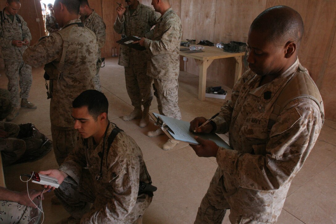 CAMP AL QA'IM, Iraq (July 18, 2005)- Hospital Corpsman 1st Class (FMF) Vincent A. Nesbitt, 34, a corpsman with 3rd Battalion, 2nd Marine Regiment, Regimental Combat Team-2 records an Iraqi soldier's heart rate while Hospital Corpsman 3rd Class Roman Cadena calculates it during a medical screening here. (Official U.S. Marine Corps photo by Lance Cpl. Lucian Friel (RELEASED)