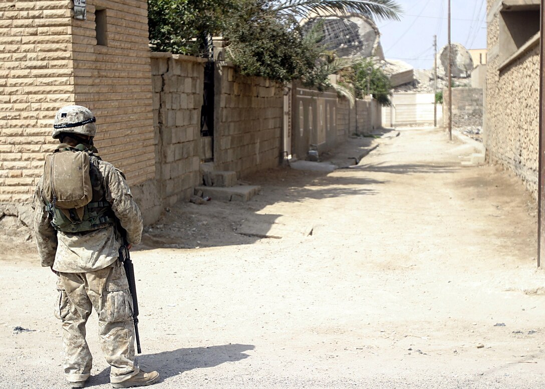 Hit, Al Anbar, Iraq (August 3, 2005)--Minneapolis, Minn., native, Hospitalman 3rd Class Chan Vang,32, with Company "I", 3rd Battalion, 25th Marine Regiment looks at a memorial destroyed by insurgents. (Official USMC Photo by Corporal Ken Melton)