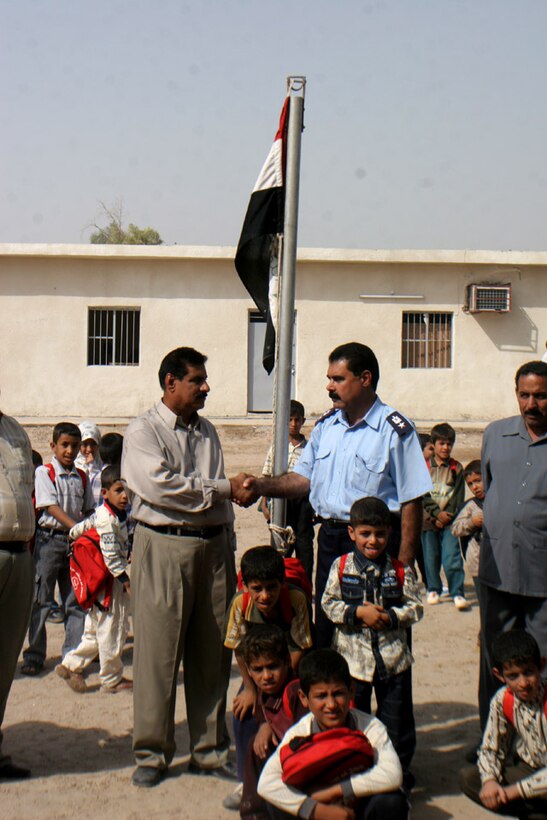 051018-M-2607O-002 KARMAH, Iraq -- The school headmaster and Karmah Police Chief Lt. Col. Dalouf shakes hands following the school opening ceremony, Oct. 18, in appreciation for each others efforts in getting the school open.  Approximately 800 students are attending the school now that it is officially open.